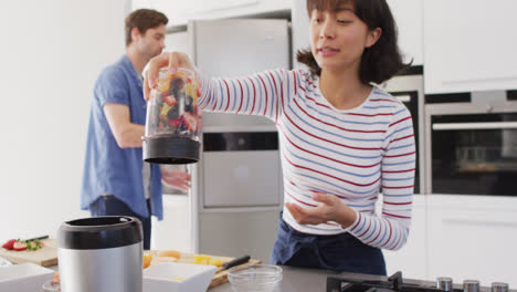 Video-of-happy-diverse-couple-preparing-juice