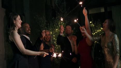 Sexy-group-of-friends-at-glamorous-party-lighting-sparklers