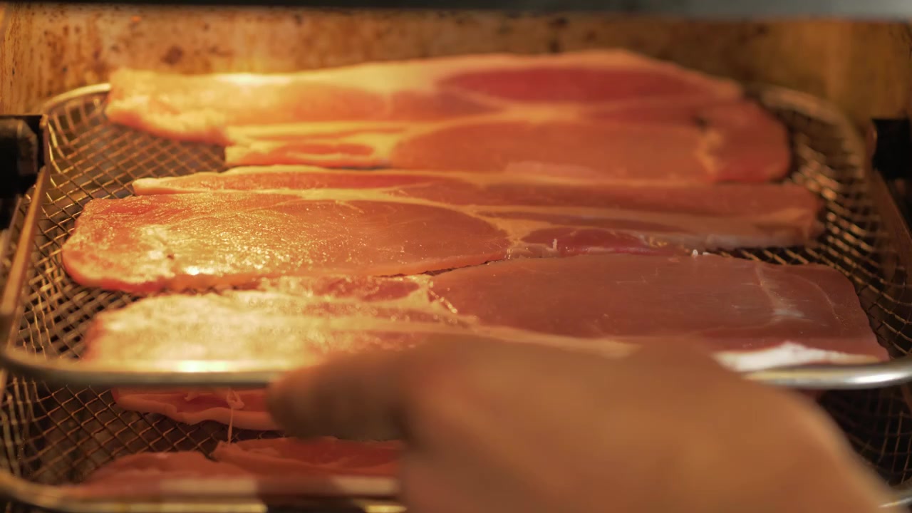 Inserimento di fette di pancetta affumicata nella friggitrice ad aria