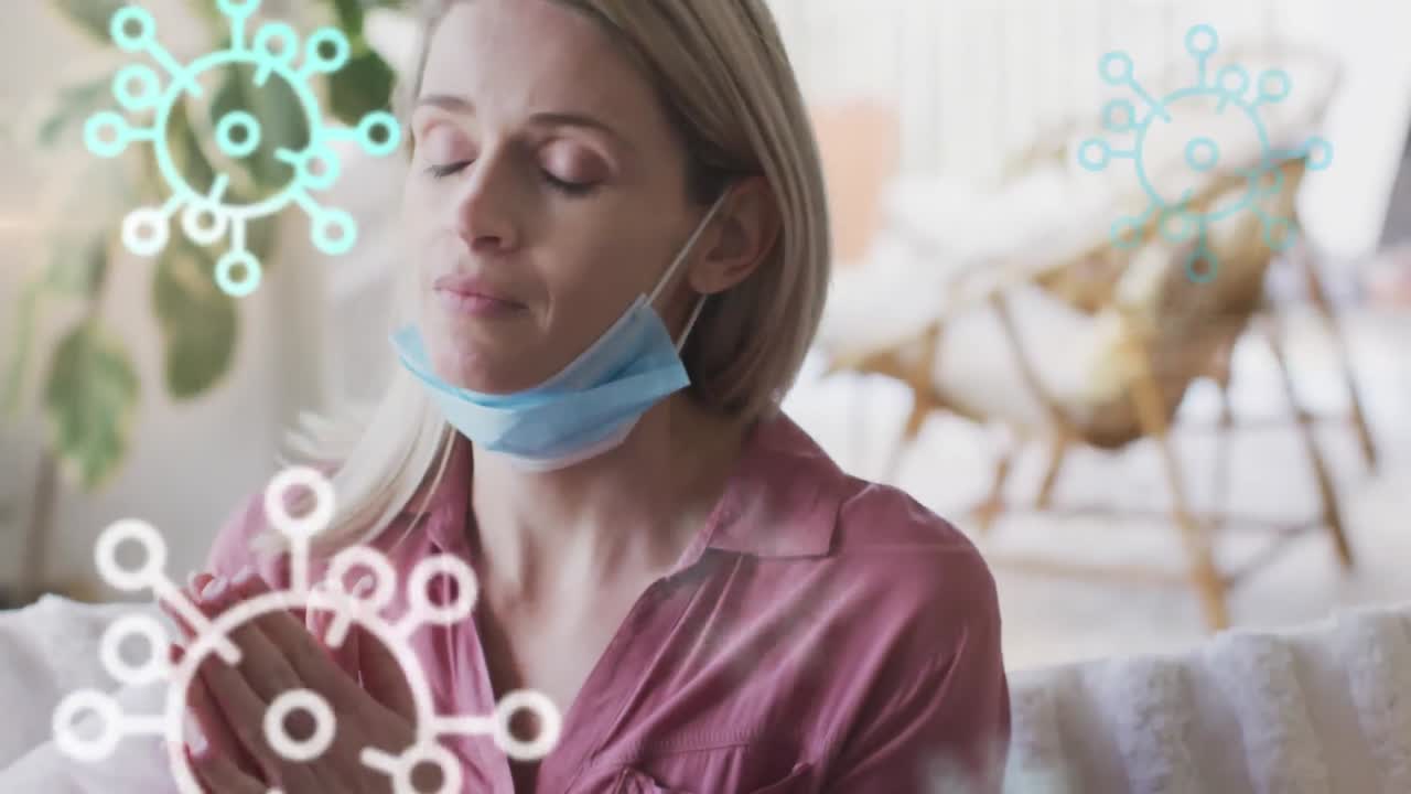 animación de las células del virus covid 19 sobre una mujer caucásica que usa una máscara facial