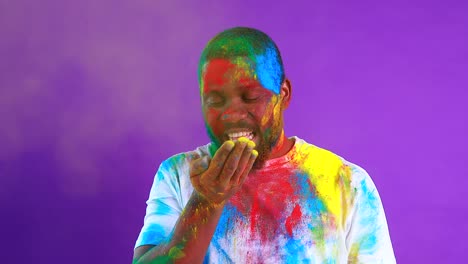hombre latino brasileño en camiseta blanca de algodón con pintura colorida de la cara riendo estudio