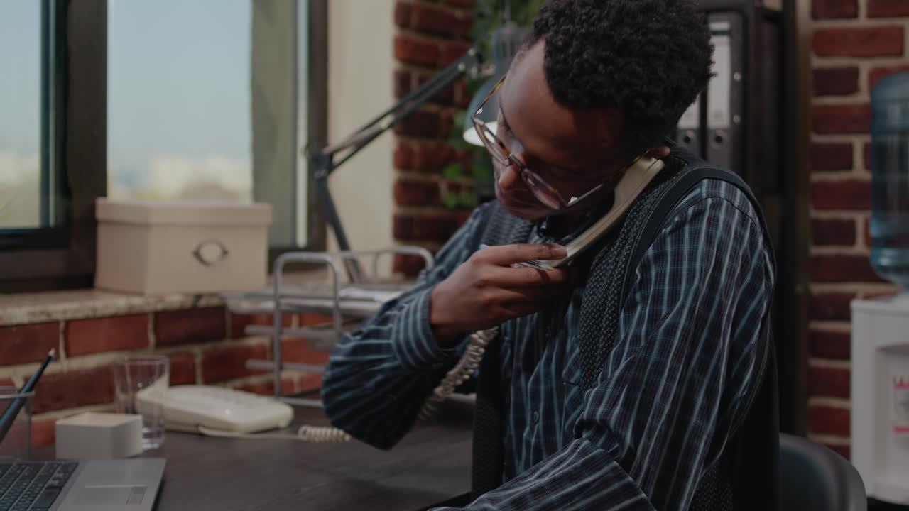 Office worker using landline phone to talk about business plan