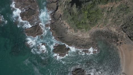 Straight-down-aerial-flyover,-rugged-ocean-cliff-and-shore-rocks