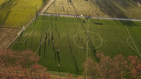 Aerial-view-over-soccer-match-during-sunset-and-foul-action-on-court,-4k-60fps