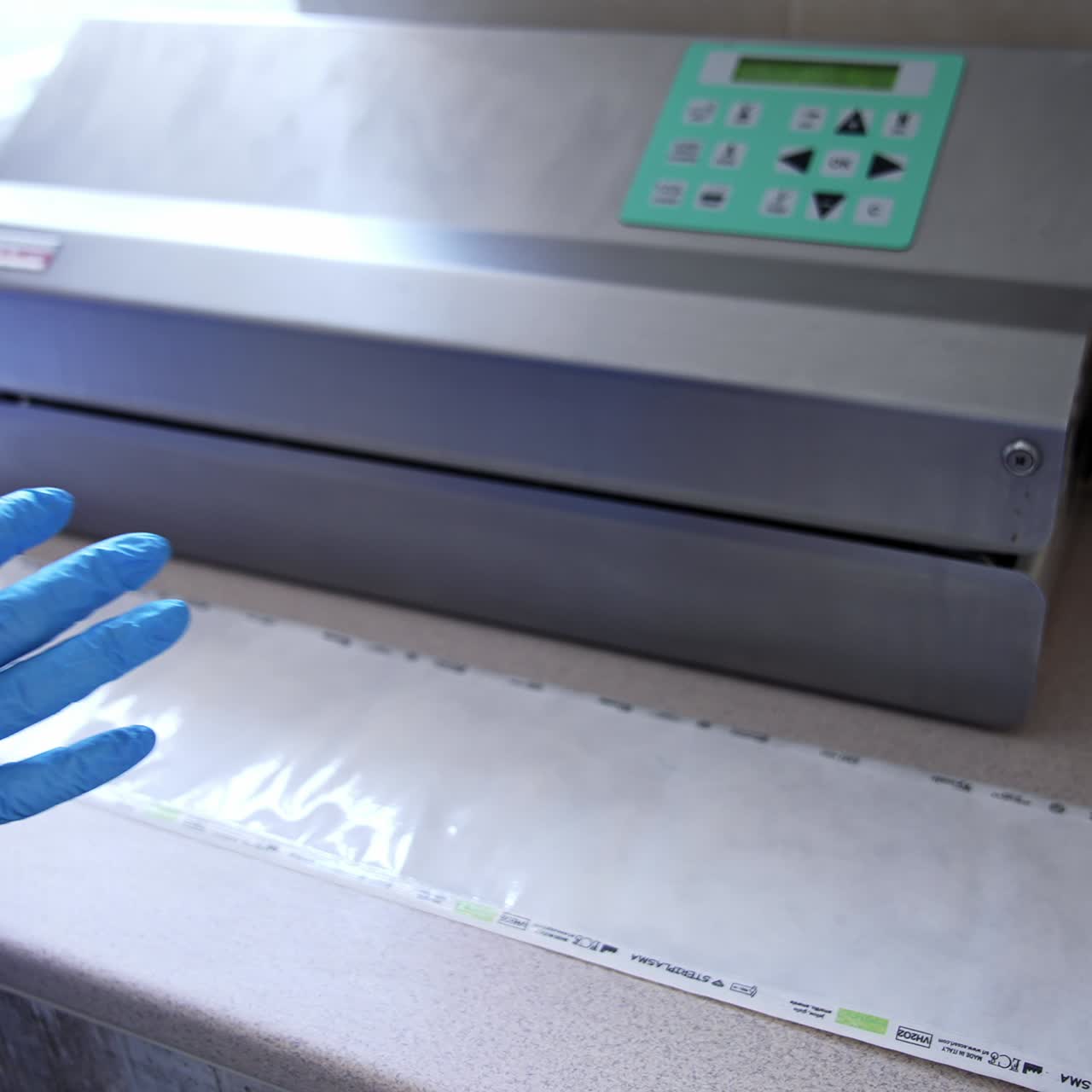 Preparation of device and tools for surgical operation. Medical staff arranges tools into a plastic bag for sterilization in modern sterilizer equipment