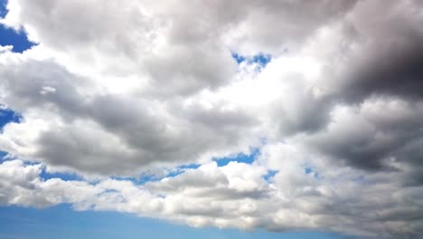 think dark cloud timeplapse with bright sunlight peeking behind the cloud with blue sky in the background