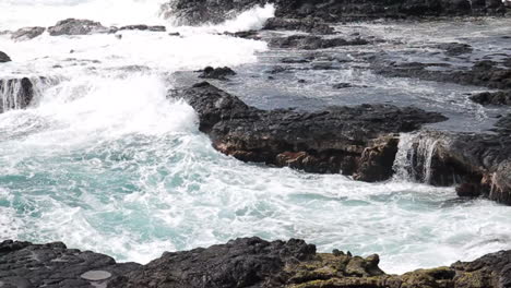 waves crash against rocky shore in hawaii