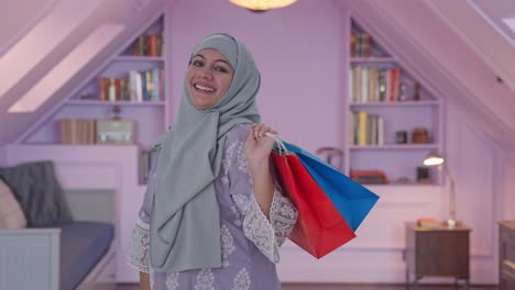 happy muslim woman posing with shopping bags