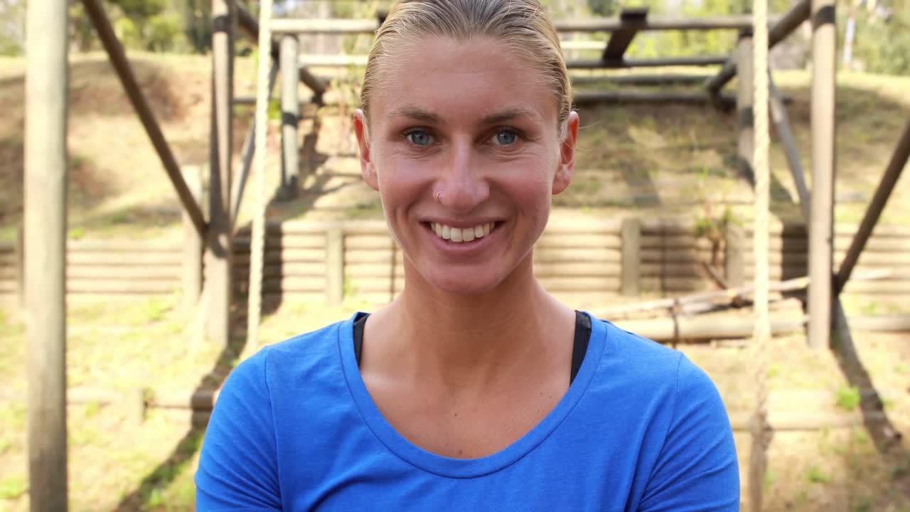 mujer en forma sonriente de pie con los brazos cruzados en el parque