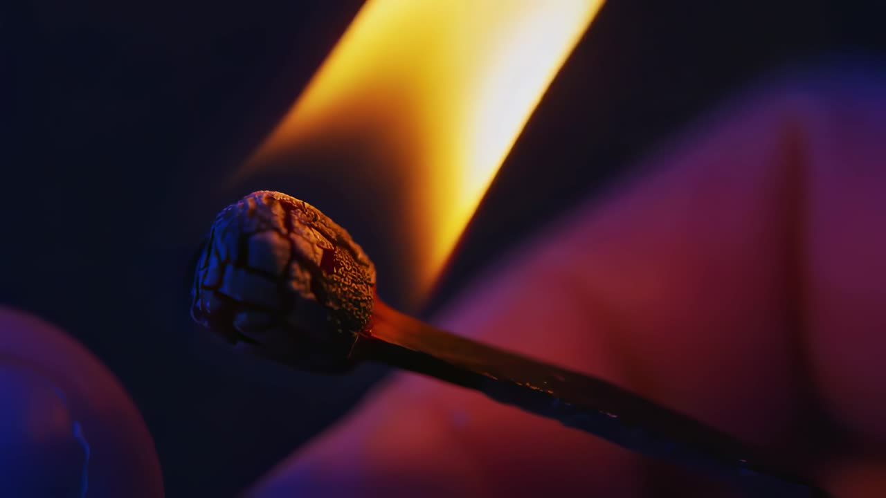 Burning wooden match revealing vibrant flame developing in slow motion against dark background, highlighting intricate details of fire's dynamic combustion process