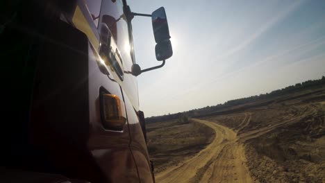 truck driving on a dirt road through a quarry