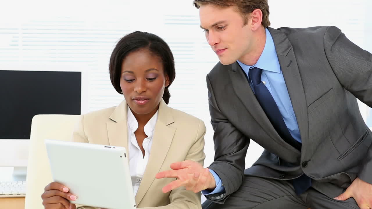 Gens d'affaires discutant à un bureau avec une tablette