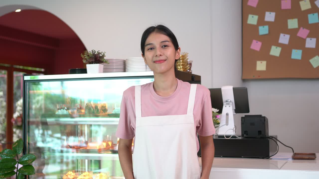 4K Portrait of Asian woman cafe waitress standing in front of bar counter crossed arms.