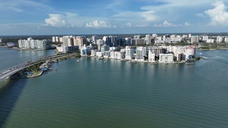 stunning aerial view of sarasota, florida’s waterfront skyline. modern beachfront condos line the coast under a bright blue sky with boats dotting the calm turquoise waters. aerial wide shot. fl, usa