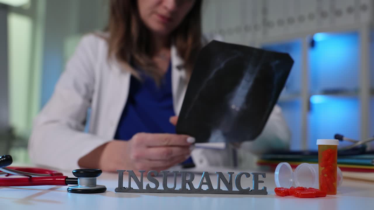 Doctor Examining X-ray with Medical Insurance Concept on Desk