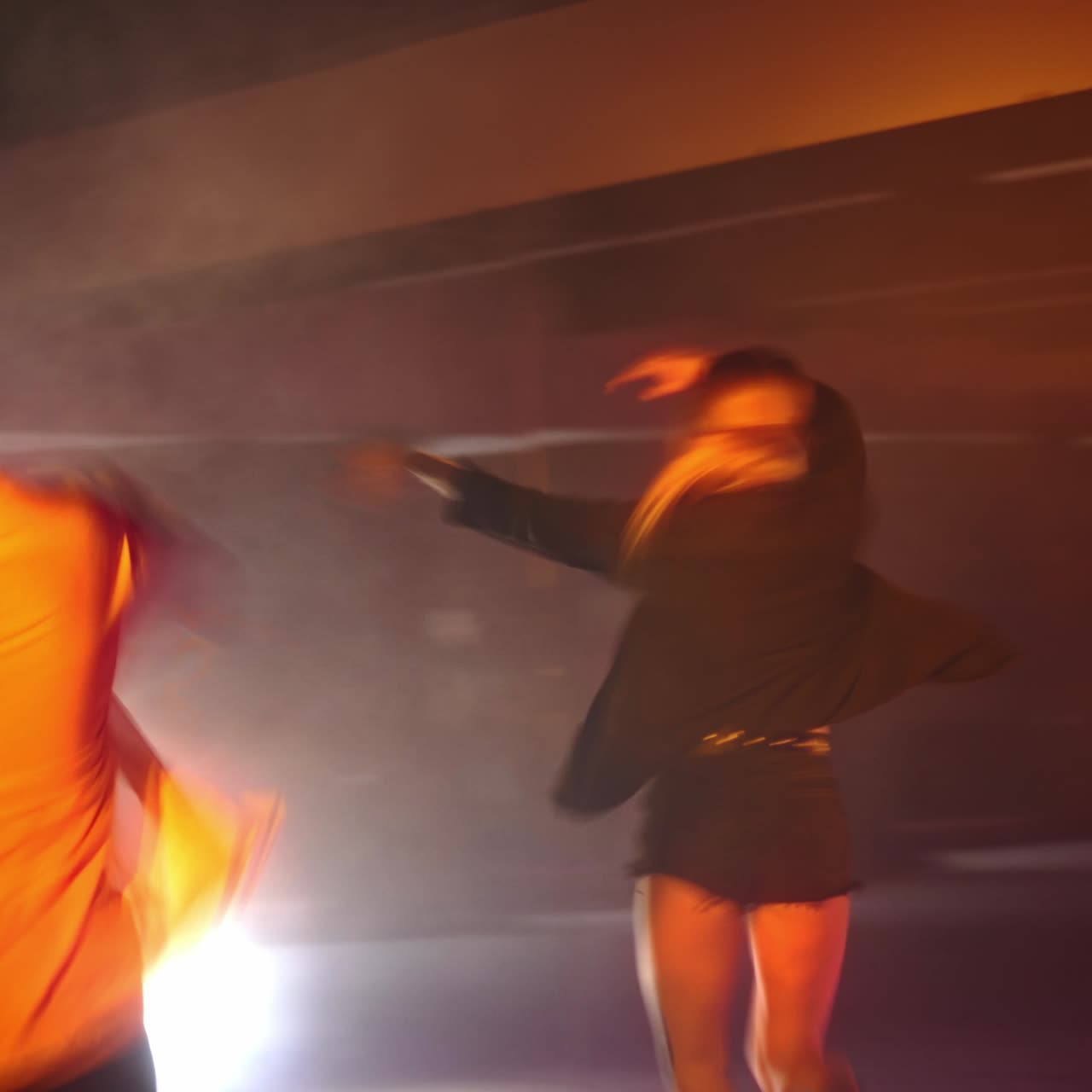 Girls band dancing energetically in the studio. Hip hop performers in the club with pink and yellow light