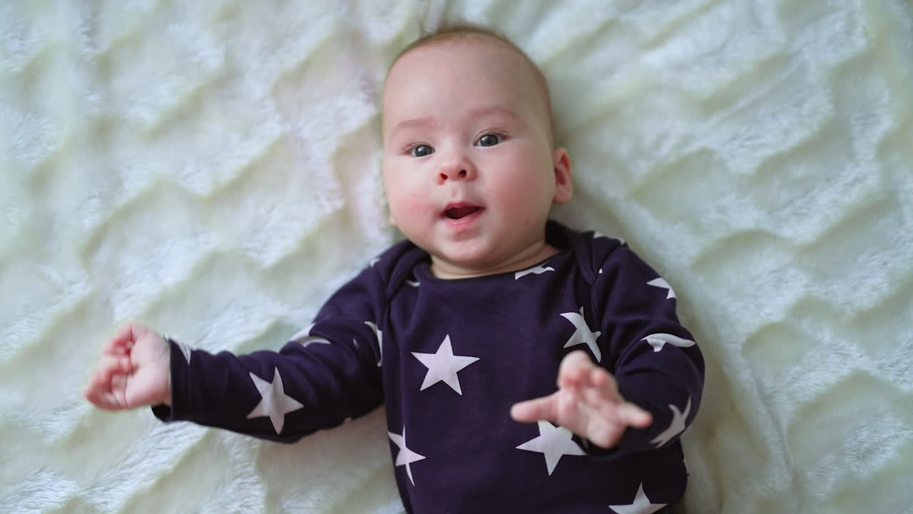 Baby liggende på et teppe