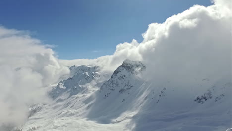 Snowy-mountain-shrouded-in-clouds-on-sunny-day