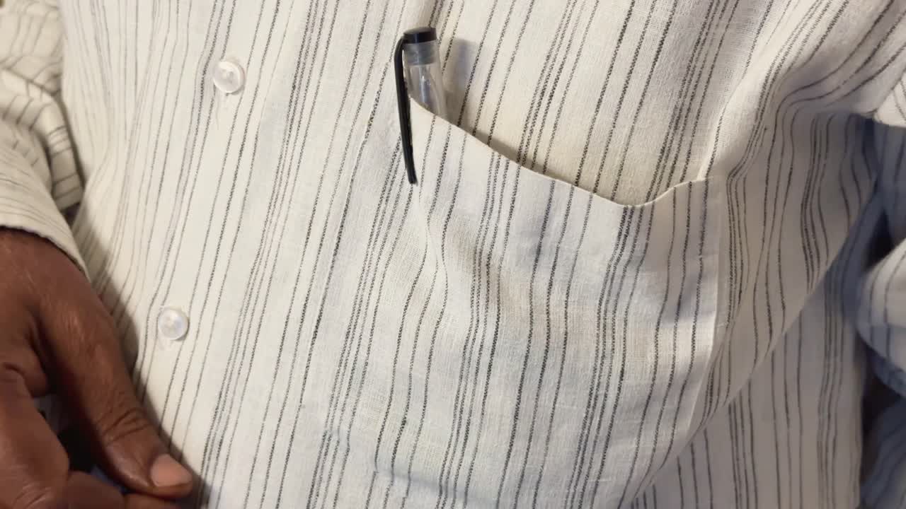 Closeup shot showing a person's hand inserting an Indian rupee note into the pocket, related to a financial transaction or the handling of money