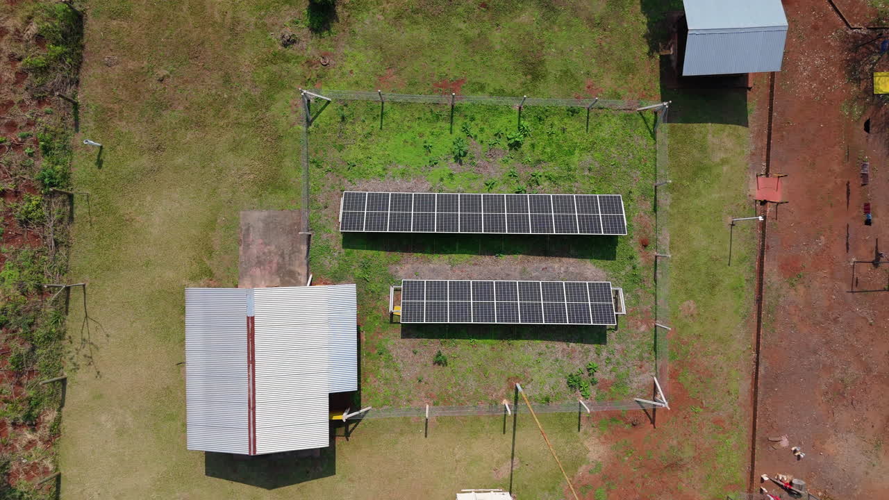 Aerial top down of a solar panel array in a green field, renewable energy installation in Argentina, tracking right