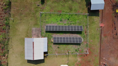 aerial top down of a solar panel array in a green field, renewable energy installation in argentina, tracking right