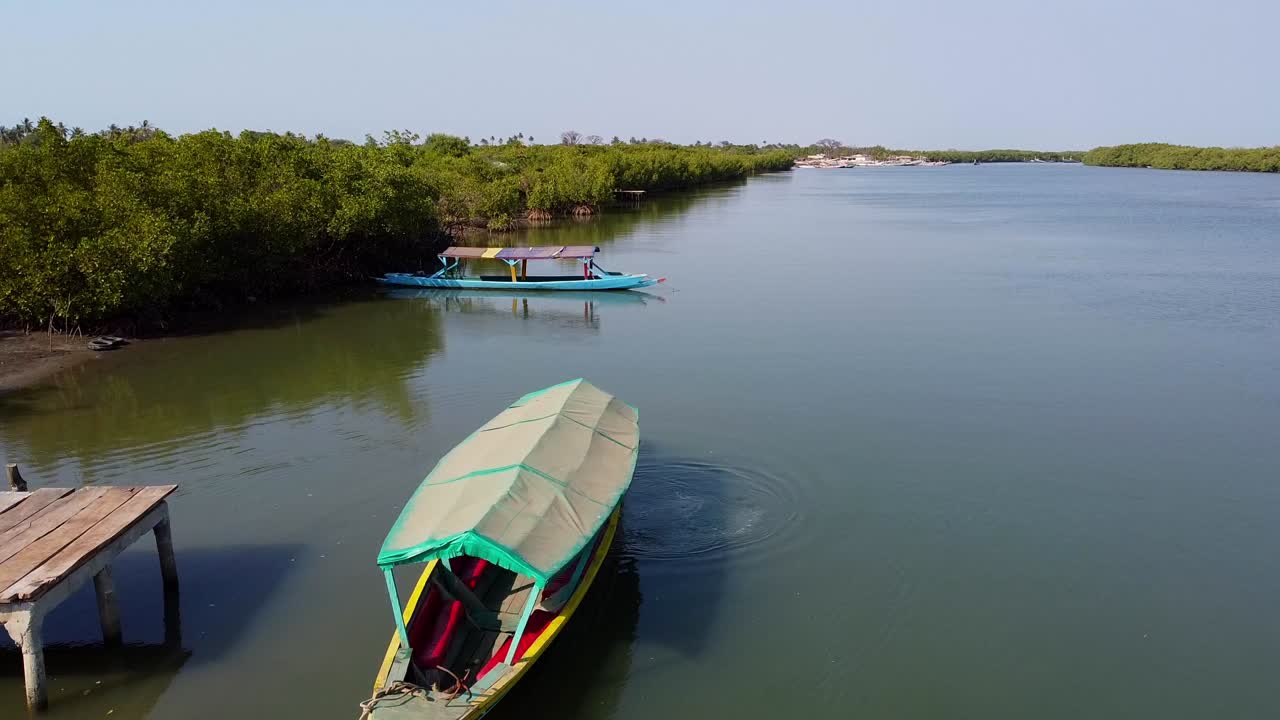 감비아의 카르톤 강 위에서 떠다니는 보트와  ⁇ 은 날에 나무와 자연이 있는 아름다운 풍경으로 촬영된 항공 드론
