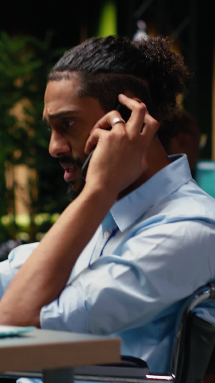 Vertical Video Middle eastern man with reduced mobility in wheelchair on phone call