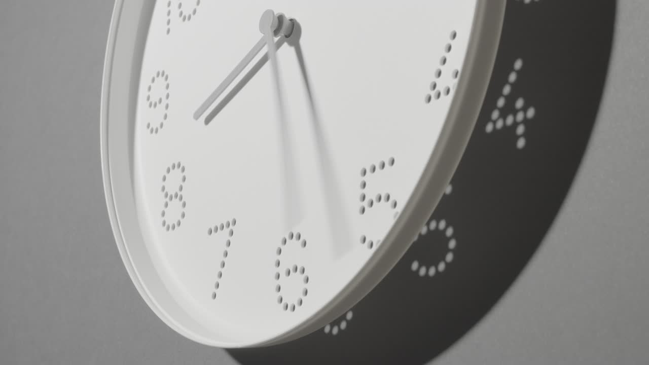 reloj blanco punteado en la pared gris todo el día