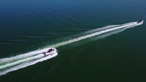 aerial over two speedboats racing fast across blue water