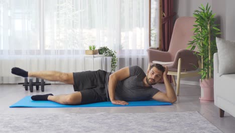 joven hombre atlético entrenando en casa estirando estirando las piernas.