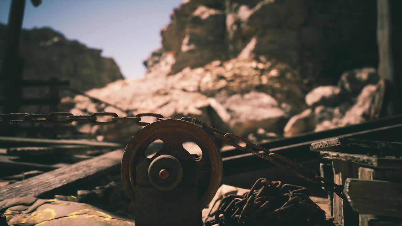 Abandoned mine with rusted tools and mountains in daylight