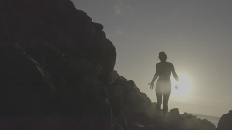 woman on rocks at sunrise