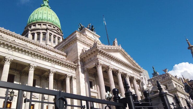 Aerial panning shot of the National Congress in Buenos Aires, Argentina. neoclassical architecture, the prominent green dome, and the historic facade of the building