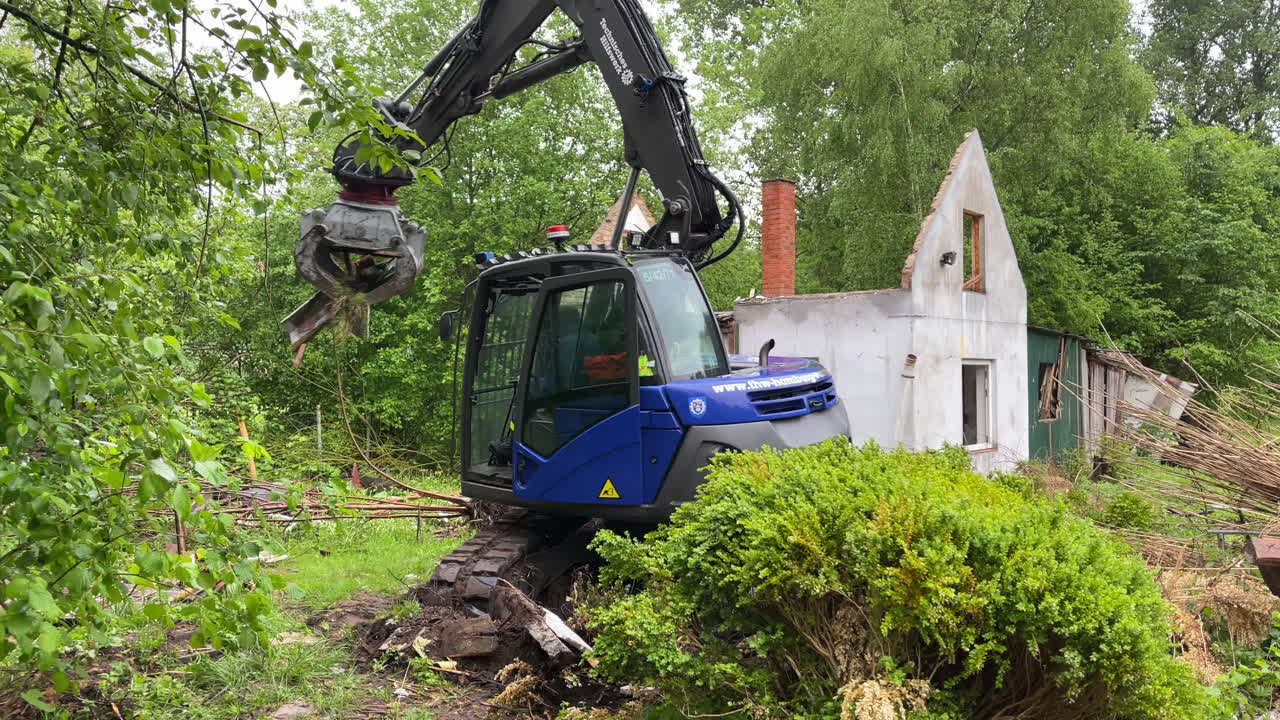 una organización de socorro técnico de empleados com thw elimina escombros de construcción con una excavadora