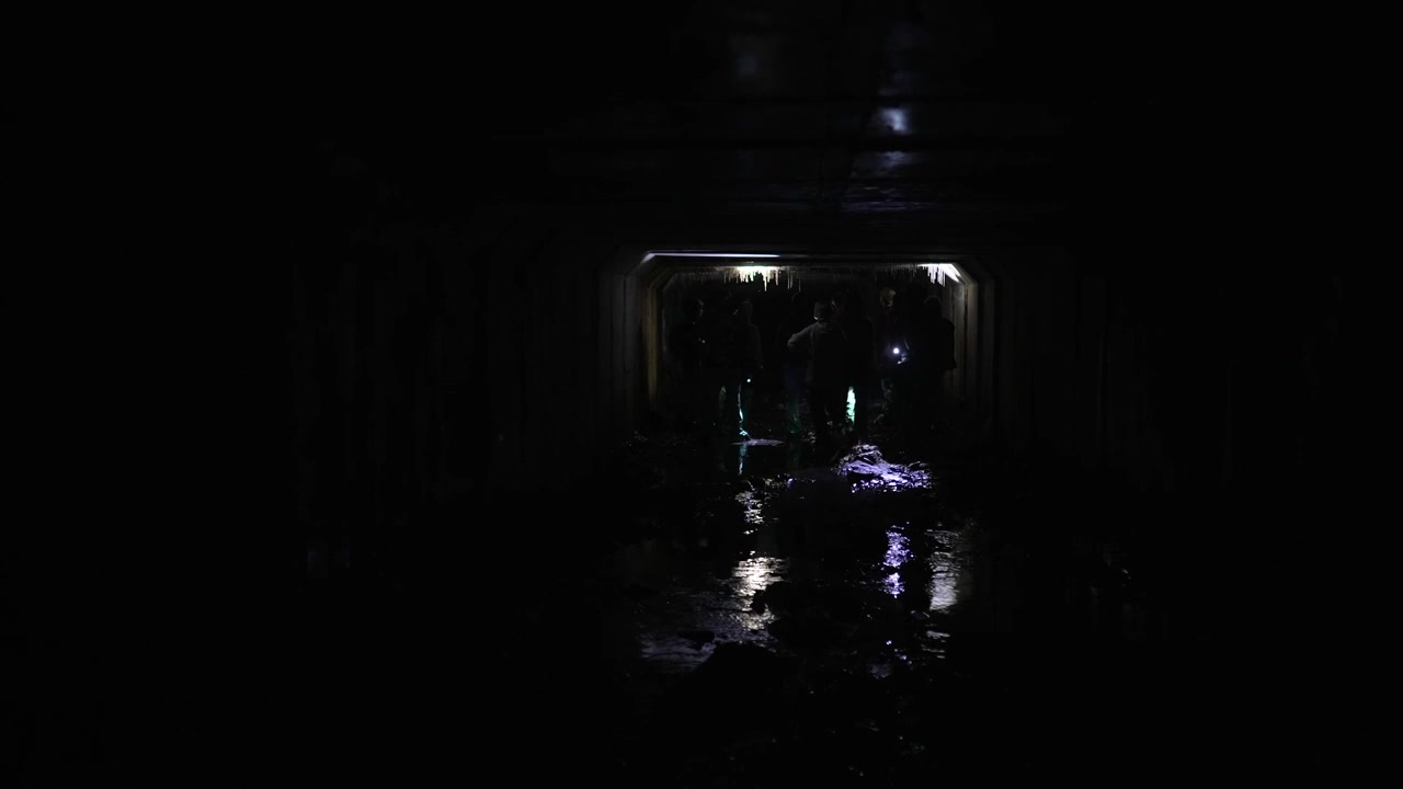 Personnes traversant un tunnel sombre