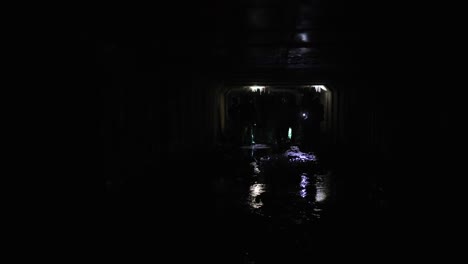 people walking through a dark tunnel
