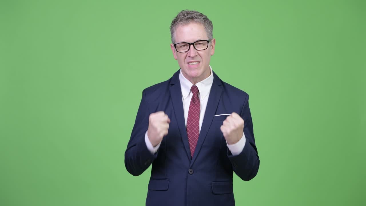 안경을 쓴 화가 난 성숙한 사업가 머리카락을 꺼내고