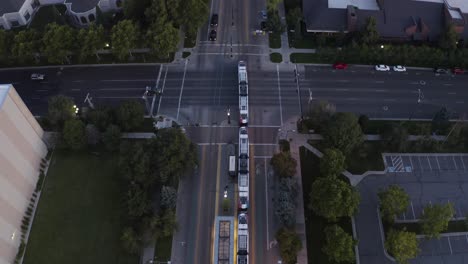 top down aerial view of a public transit cable car passing through the streets at night