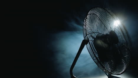 fan blades rotate in rays of light and fog. copyspace composition