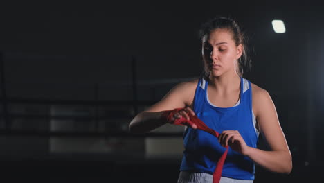 hermosa mujer luchadora preparándose para la batalla en cámara lenta termina en sus manos con vendas de boxeo