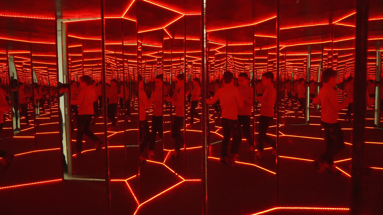 Boy playing with distorted mirror. Museum of entertaining sciences