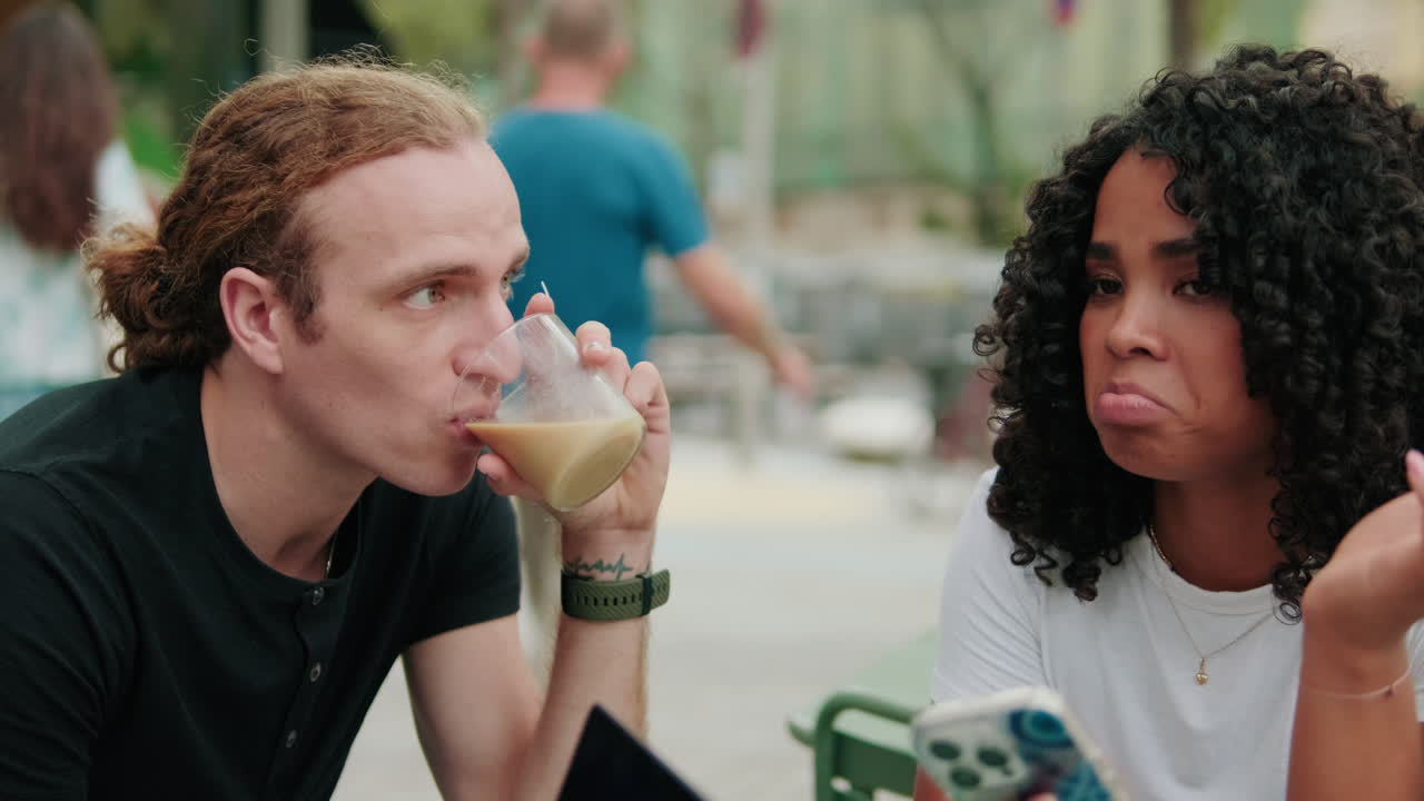 International student couple prepares to study outdoors, using smartphone