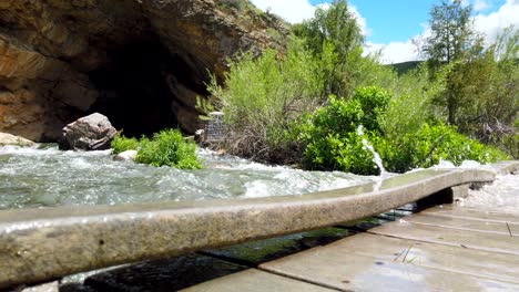 rushing water is seen flowing over a bridge