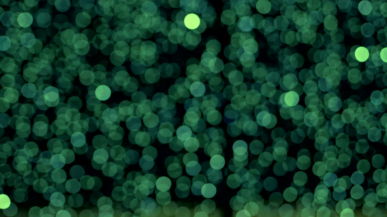 Night abstract green background is defocused with nice bokeh. Blurred Christmas Lights Bokeh. Pan across blur .