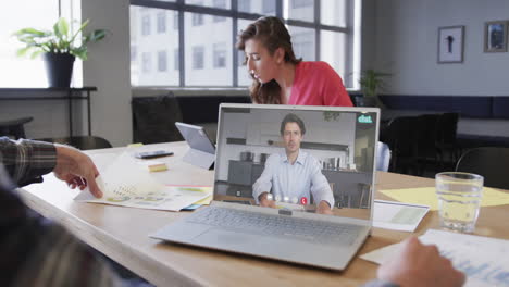 hombre de negocios caucásico en una videollamada con un colega caucásico en la pantalla