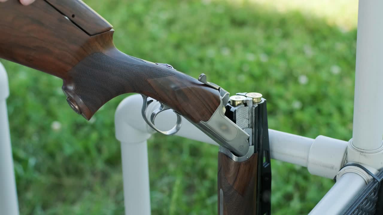 un deportista dispara con una escopeta de doble cañón, un campo deportivo para una prueba de tiro está disparando a un esquete volador