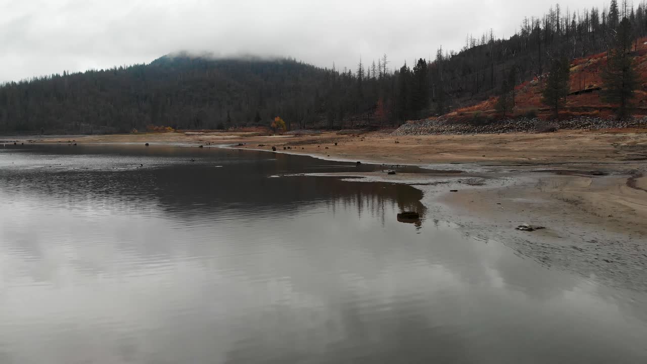 Ripresa aerea di nuvole temporalesche scure sopra un lago.