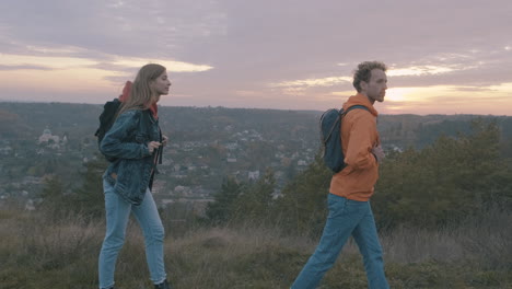 joven pareja de excursionistas en la cima de la montaña hermosa puesta de sol