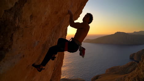 a rock climber on a cliff at sunset