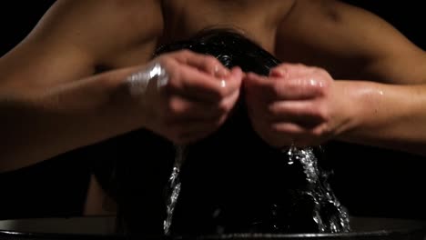 young woman having a bath in a white metal barrel and cleaning his hair with clean water